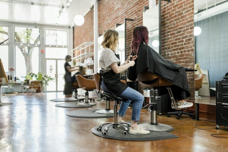 Hairstylist trimming hair of the customer in a beauty salon